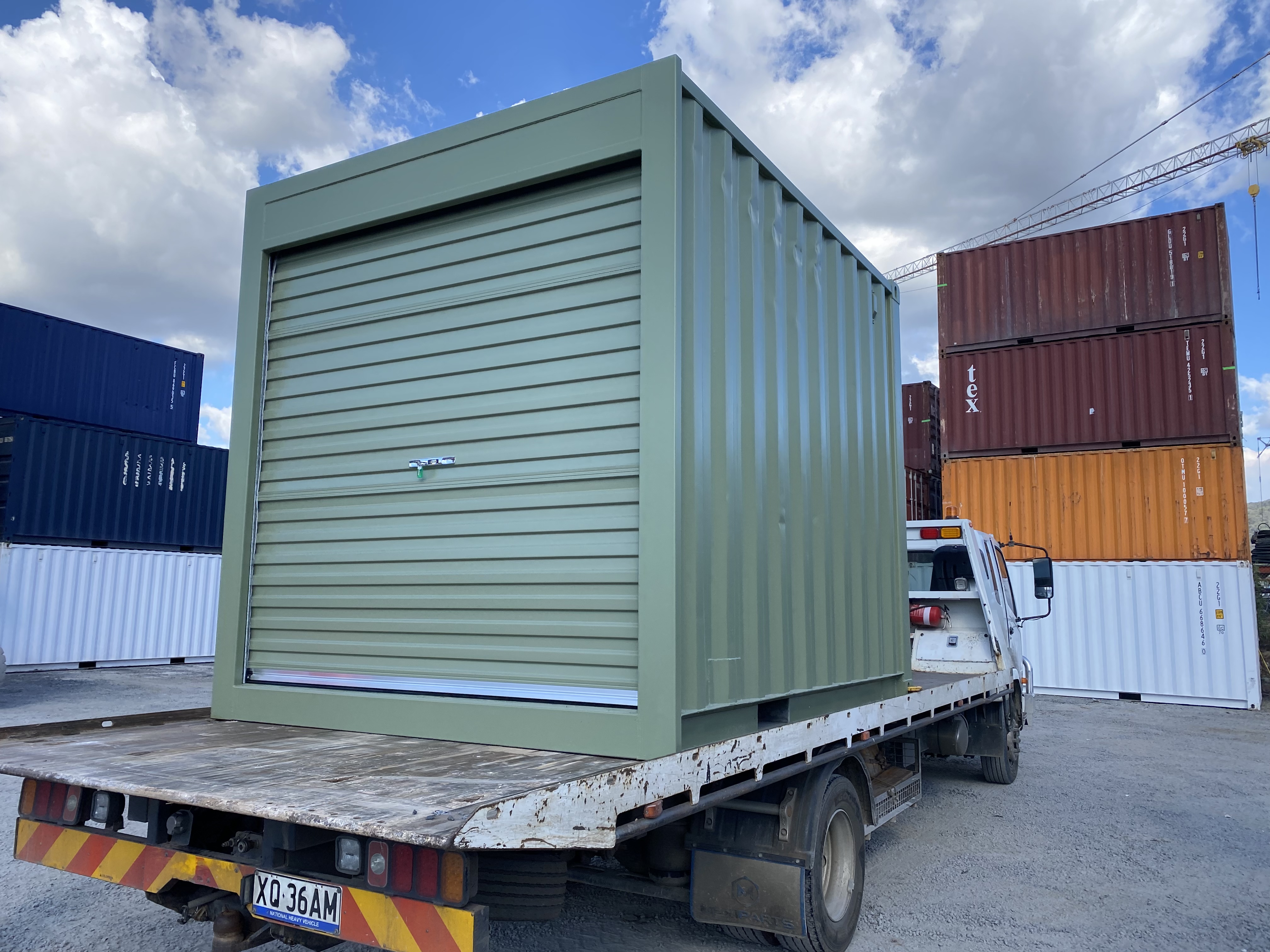 10ft shipping container with a roller door on a tilt tray truck
